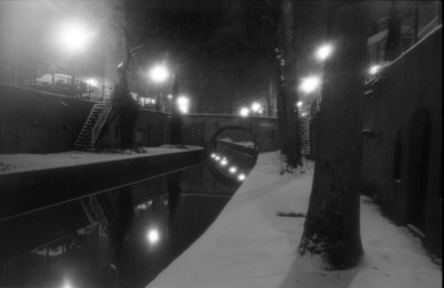 883882 Gezicht op de Nieuwegracht te Utrecht, tijdens winterse omstandigheden, bij nacht.